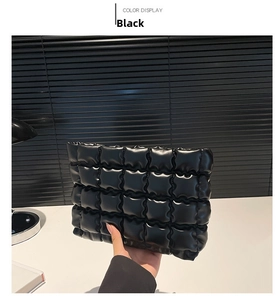 Détail d'une pochette matelassée noire élégante avec une texture à carreaux à bulles chic