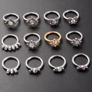 Set of 12 stainless steel opal and zircon nose rings with floral designs on dark background