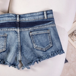 Detailansicht der Patchwork-Jeansshorts mit ausgefransten Kanten und Kontrasttaschen