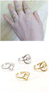 Detail view of 18K stainless steel open rings with four-leaf clover and geometric motifs