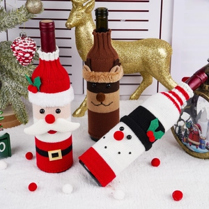 Close-up of knitted Christmas wine bottle covers featuring Santa, reindeer, and snowman designs
