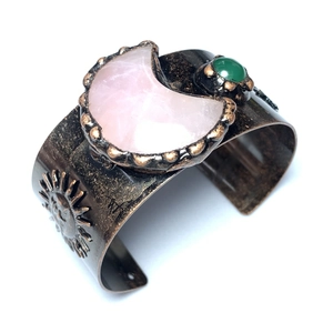 Detail der Sonnenmotive auf einem Vintage-Bronze-Armreif mit rosa Mondstein-Besatz