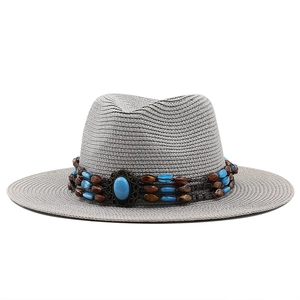 Détail d'un chapeau en paille gris avec ruban ethnique perlé et centre en turquoise
