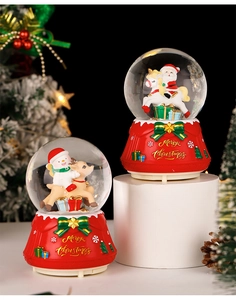 Close-up of Christmas crystal balls with Santa Claus and snowman on red bases