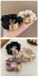 Détail de chouchous en satin avec boucles métalliques dorées aux tons neutres