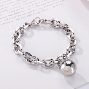Detail of silver stainless steel chain bracelet with a polished hollow ball charm