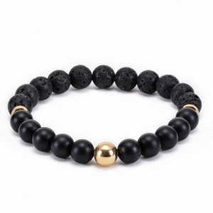 Detailed close-up of volcanic lava stone and matte black beads with gold spacer charm