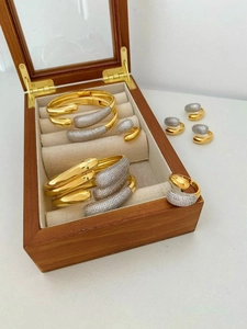 Macro view of copper gold bracelets and rings set with cubic zirconia in a jewelry box
