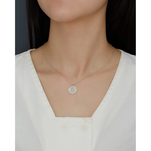 Detailed view of a silver sterling necklace featuring a round snake pattern pendant