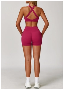 Dettaglio del set yoga rosa acceso con reggiseno sportivo incrociato e pantaloncini a vita alta