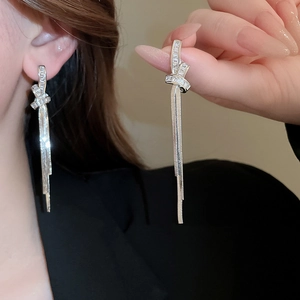 Detailansicht der glitzernden silbernen Quastenohrringe mit Kristallknoten am Model
