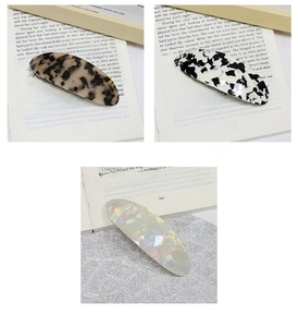 Detailed trio view of oval acetate hair clips in tortoiseshell and marble patterns