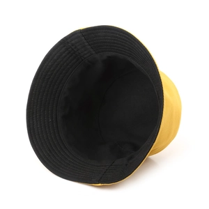 Close-up view of a reversible yellow and black cotton bucket hat for sun protection
