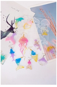 Detail showing various ocean-themed resin jewelry charms and clear silicone molds