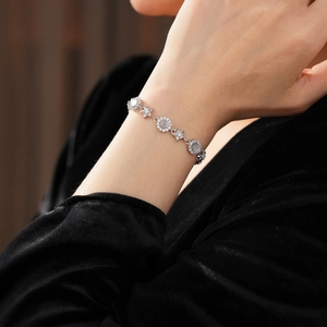 Macro shot of a silver bracelet with translucent round gemstone and small star-shaped zircons