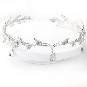 Close-up of silver bridal tiara featuring rhinestone leaf patterns and teardrop crystal pendants