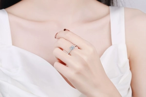 Detailed view of square moissanite ring with side stones worn on finger