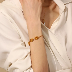 Detail eines böhmischen 18K vergoldeten Edelstahl-Muschelarmbands am Handgelenk