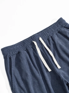 Macro detail of dark blue waffle knit fabric with white drawstring and elastic waistband
