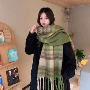 Thick mohair checkered scarf with tassels in green and white, styled on a model indoors