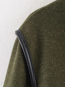 Detailed view of army green wool fabric with premium black PU leather piping accents