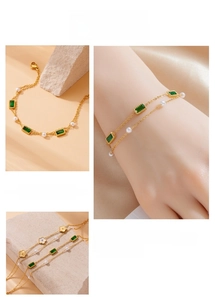 Detail of gold-plated double-chain bracelet with green emerald gems and pearls