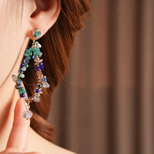 Detail of vintage beaded fringe earring with multi-colored crystals and gold finish