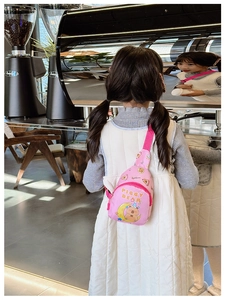 Vue arrière d'un enfant portant un sac de poitrine rose avec un ours assis sur la lune