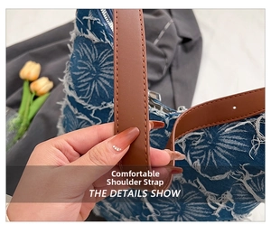 Detail of comfortable brown leather shoulder strap on a vintage denim tote bag