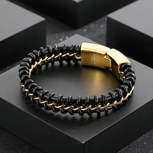 Detail of black braided leather bracelet with gold stainless steel clasp and engraving