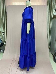 Detail of royal blue tiered maxi dress featuring off-shoulder puff sleeves and satin texture