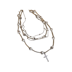 Three-layer layered necklace featuring a silver cross pendant and white faux pearls
