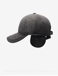 Detail of dark grey winter baseball cap with ear flaps and metallic B logo accent