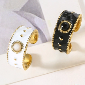 Macro shot of wide-band enamel rings with natural stone and golden beaded edges