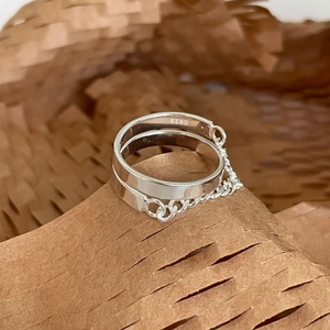 Minimalist 925 sterling silver double ring with a delicate chain link on paper background