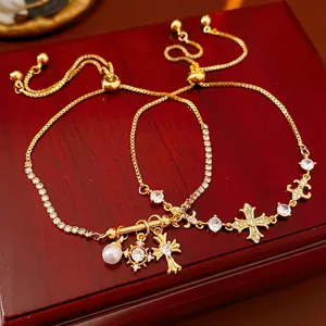Bracelets dorés avec croix, perles et cristaux étincelants sur un coffret à bijoux de luxe