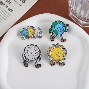 Cute cartoon enamel pins featuring happy earth sun and moon on a white ceramic tray