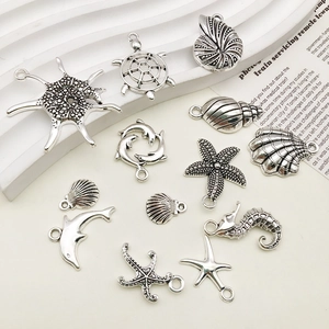 Macro view of ocean themed antique silver charms including starfish, turtles, and seashells