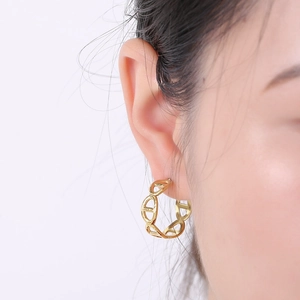 Macro shot of 18K gold plated titanium earring featuring a geometric pig nose design