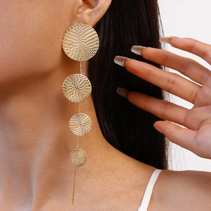 Golden geometric round fringe earrings with woven texture worn by a female model