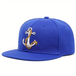Close-up of royal blue snapback cap featuring detailed silver and gold anchor embroidery