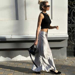 Scatto street style con top nero senza maniche e gonna lunga a sirena in raso argento