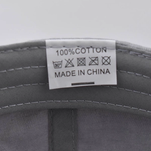 Detail shot of the 100% cotton wash label and care instructions inside the baseball cap