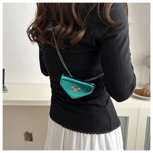 Close-up of metallic teal triangle bag with silver bow buckle and chain strap