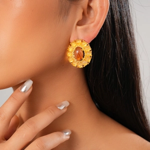 Detailed view of vintage gold stud earrings with oval amber stones and yellow crystals