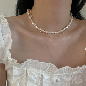 Close-up of double layer necklace with freshwater pearls and delicate gold chain