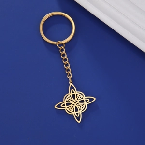 Macro shot of a golden stainless steel Celtic knot pendant keychain on blue surface