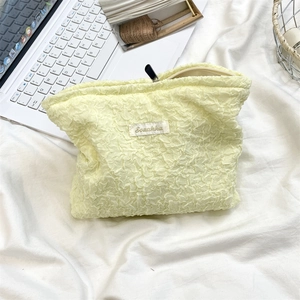 Close-up of yellow bubble textured cosmetic bag with zipper and Sozakka label