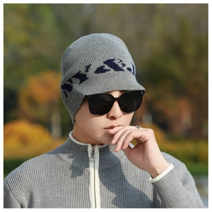 Detail of grey knitted beanie with blue woven patterns and dense winter texture