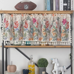 Detail of short curtain valance with tropical floral patterns and bottom tassel fringe